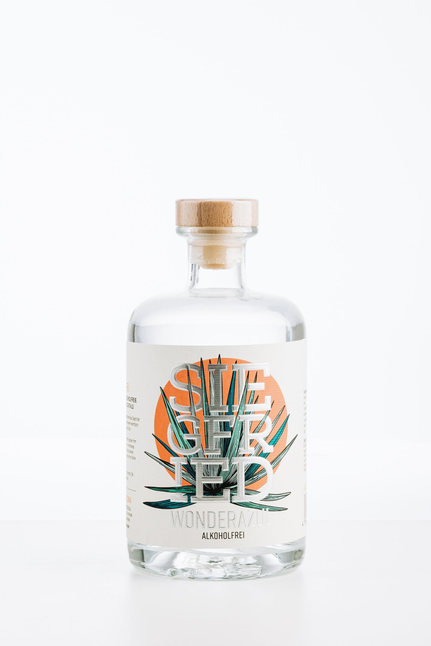 Siegfried Wonderazul alkoholfrei – klare Flasche mit Holzverschluss und stilisiertem Agaven-Etikett vor roter Sonne, alkoholfreie Agaven-Spirituose für Margarita & Paloma